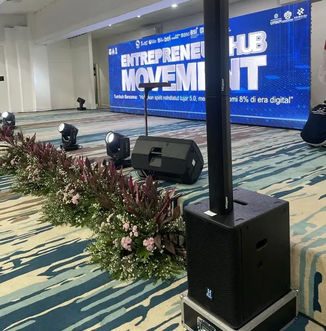 Pengeras suara dan lampu panggung di depan layar LED